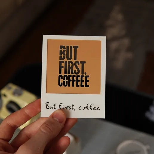 Câmara branca de impressão de café junto a uma chávena com desenho de rosto
